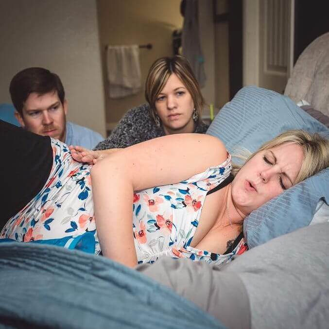 Donna sdraiata sul letto con contrazioni
