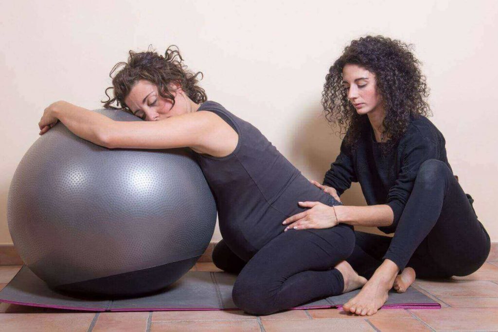 Ostetrica che massaggia donna incinta su fitball